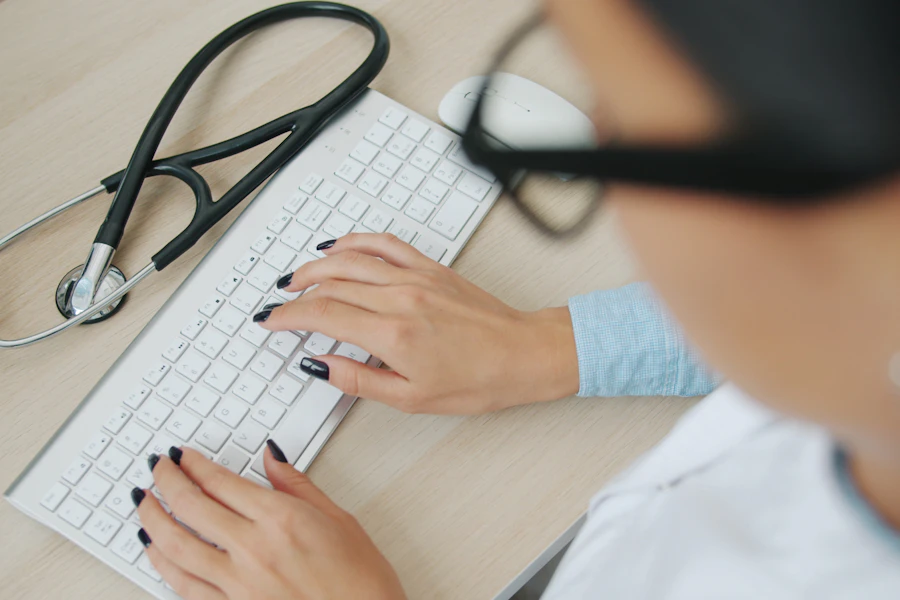 Tangan mengetik di keyboard dengan stetoskop di meja (foto ilustrasi)